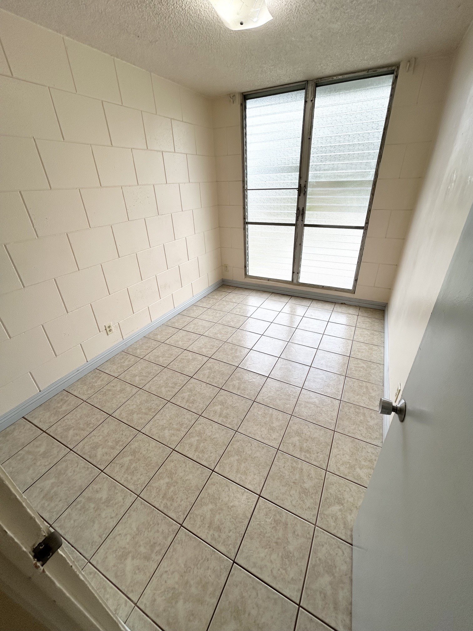 A room with a tiled floor and a window.